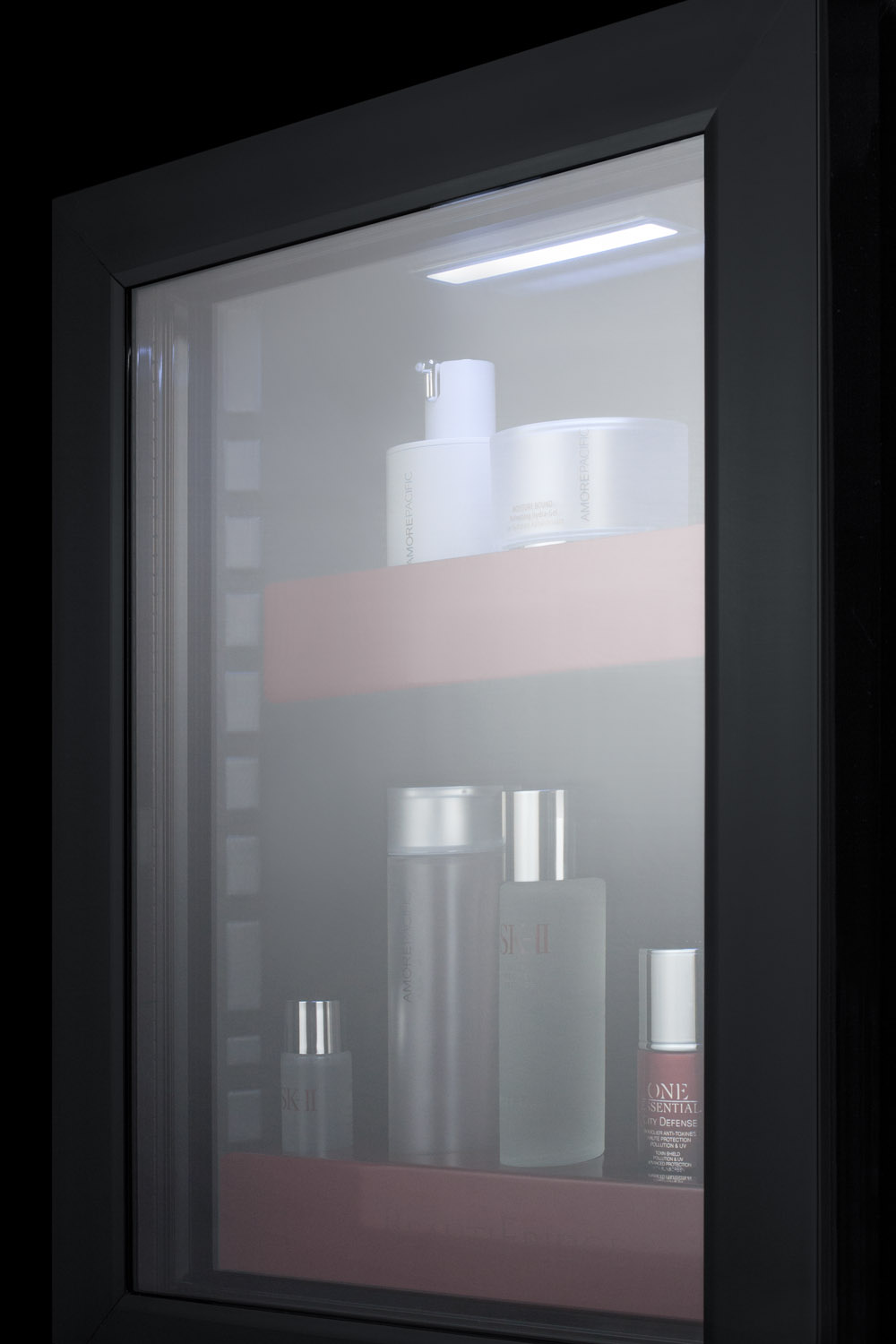 BeautiFridge compact cosmetics cooler with glass door, black cabinet, lock, glossy ruby-colored shelves, and digital controls set for the storage of beauty products